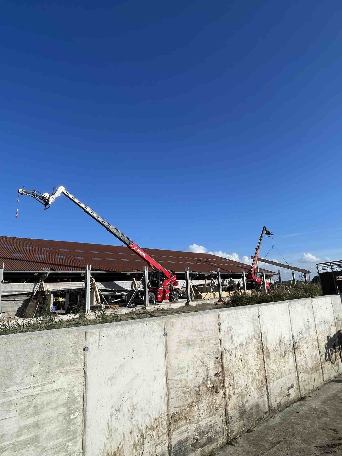 Ein Kran steht auf einer Betonmauer neben einem Gebäude.
