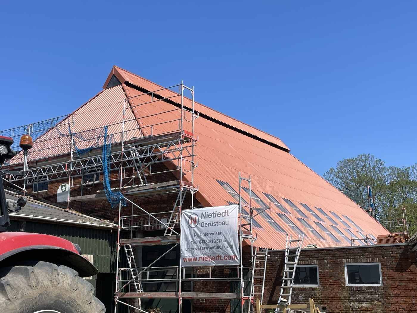 Ein Traktor steht vor einem im Bau befindlichen Gebäude.