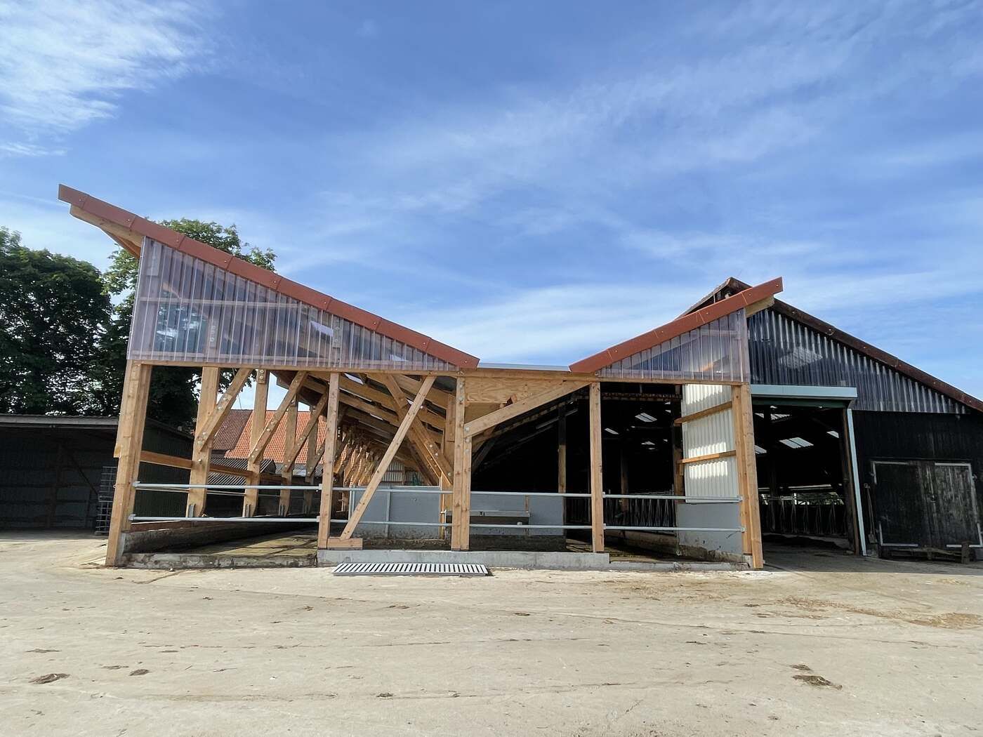 Auf einem Feld wird ein Gebäude errichtet, im Hintergrund ist ein blauer Himmel zu sehen.
