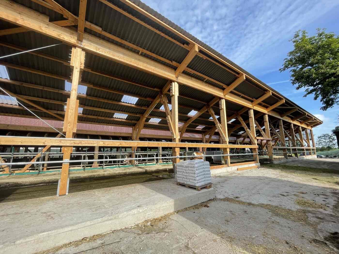 Eine große Holzscheune mit einem mit Schindeln gedeckten Dach.