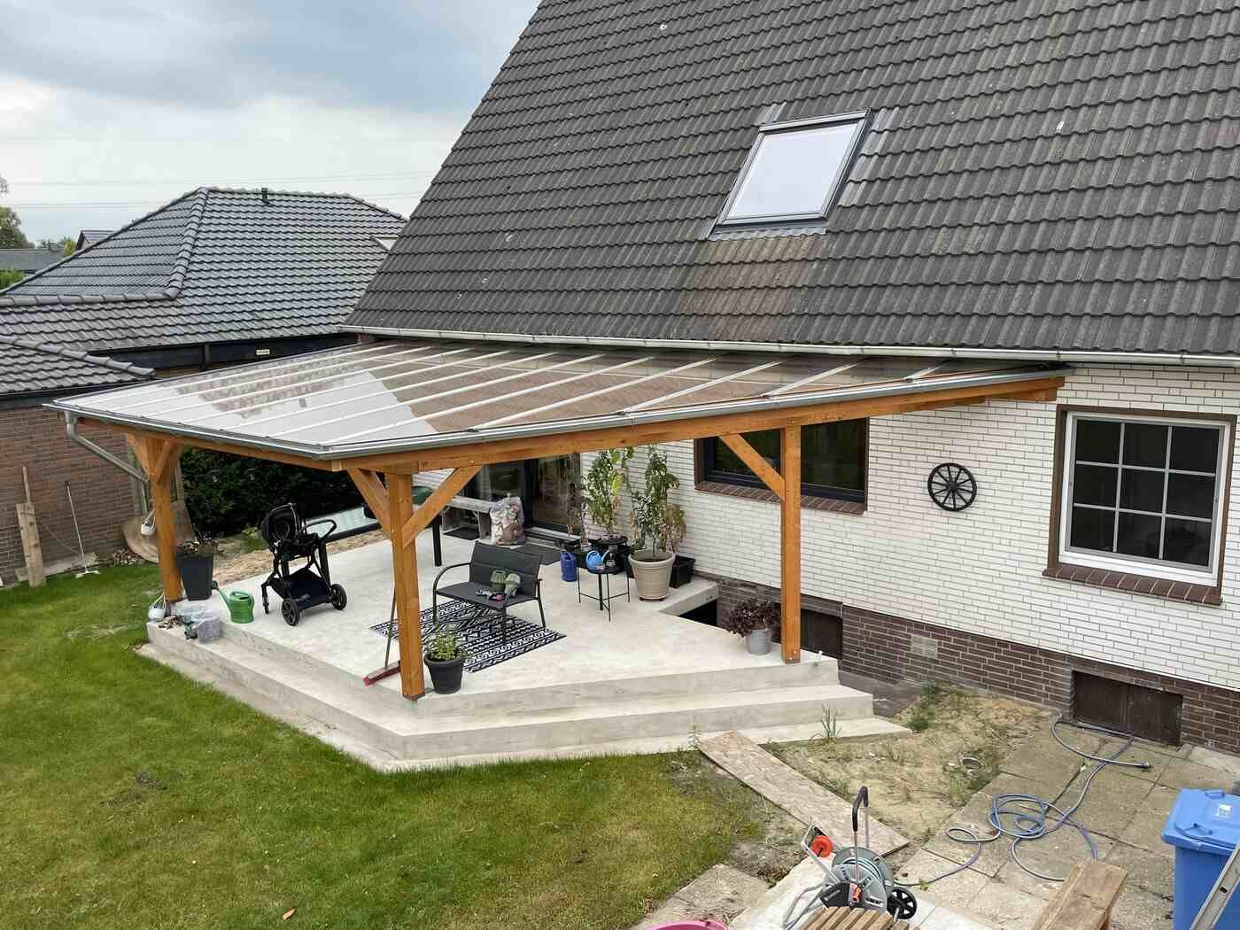 Ein Haus mit einer überdachten Terrasse davor.
