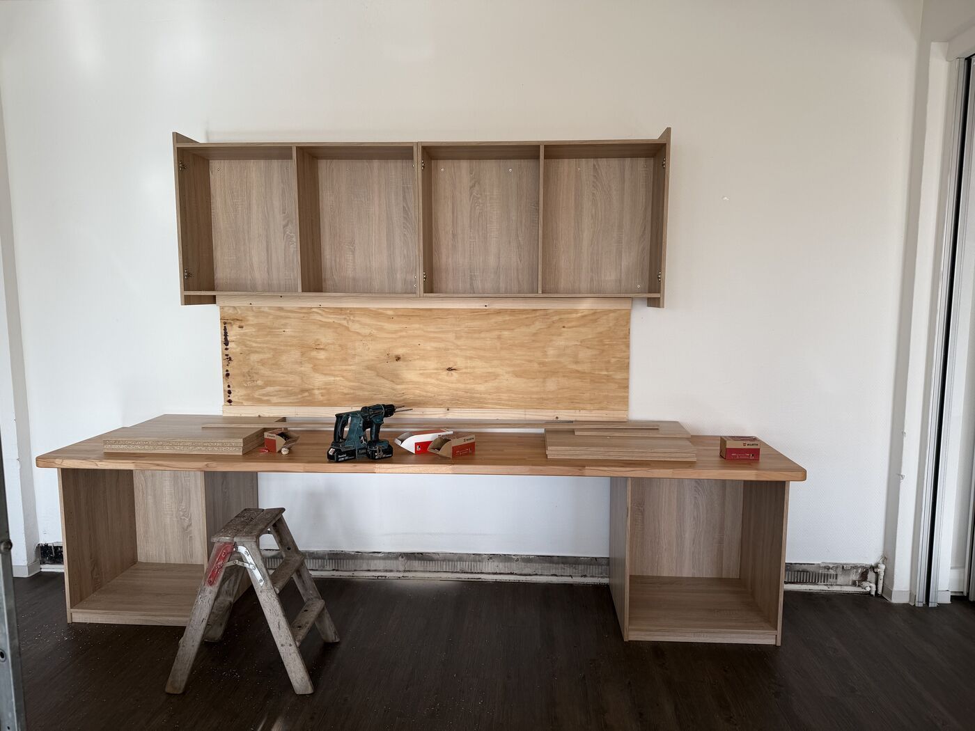 In einem Raum mit einer Leiter wird ein Holzschreibtisch gebaut.