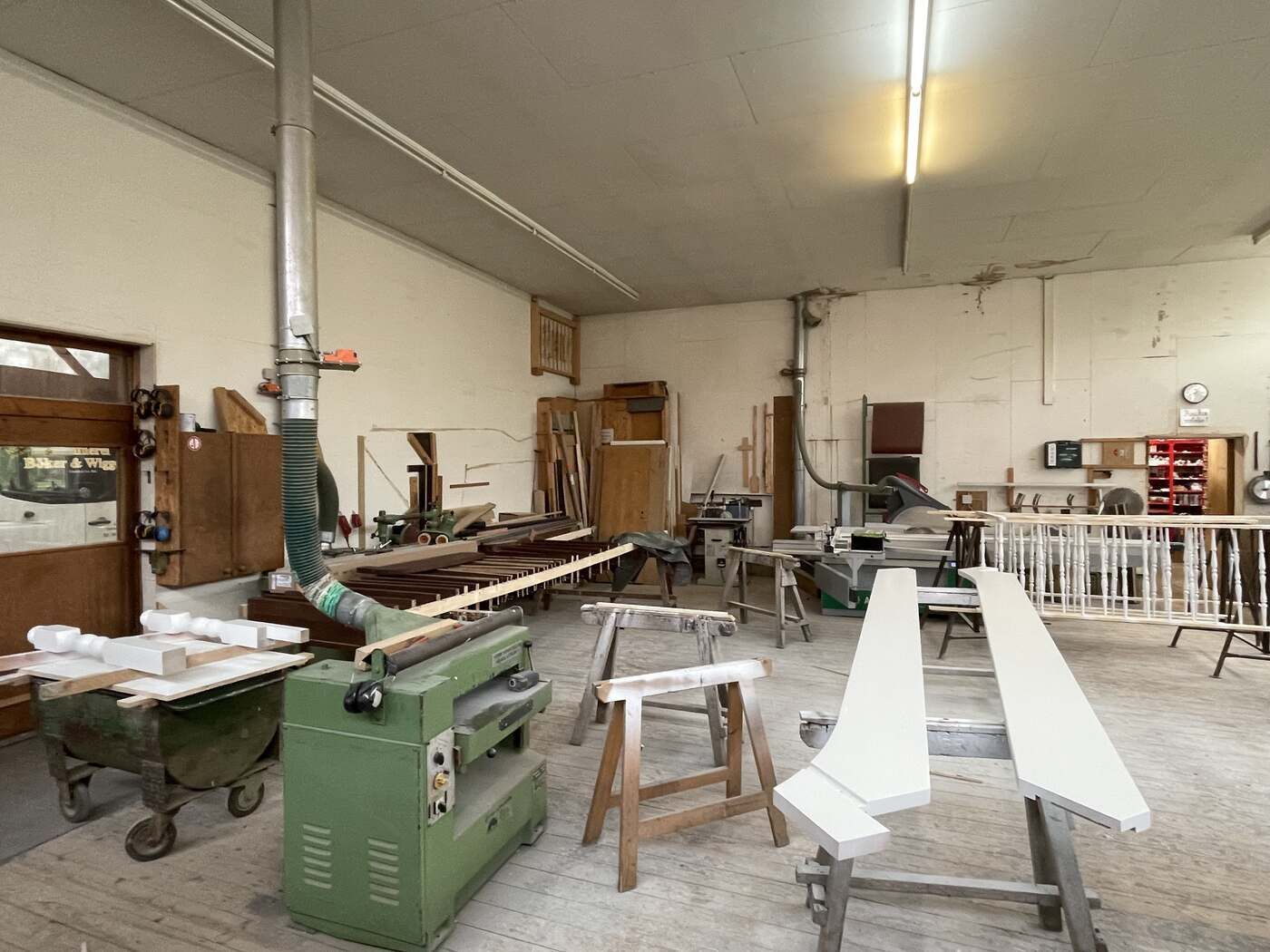 Eine Tischlerei mit einer grünen Maschine in der Mitte