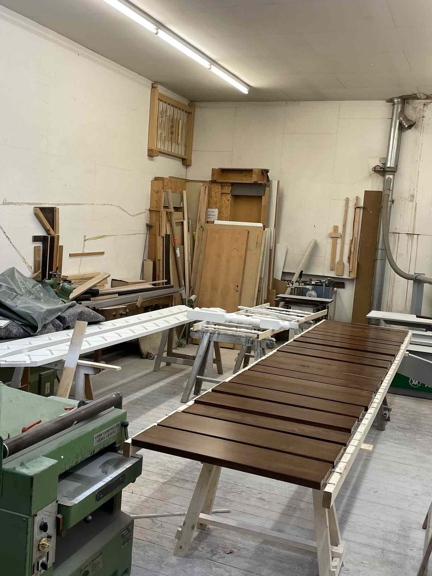 Eine Holzwerkstatt mit einem großen Holztisch in der Mitte