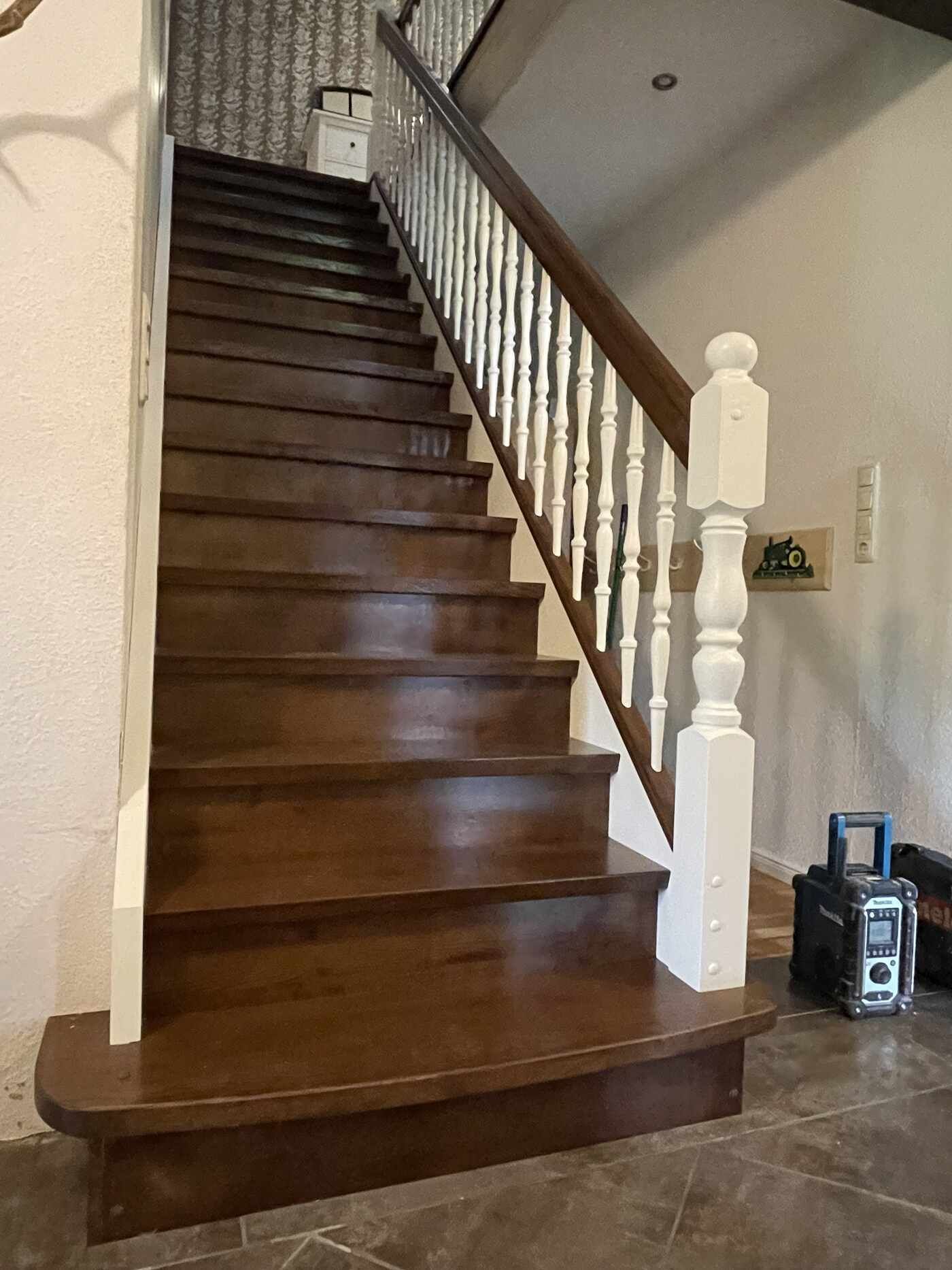 Eine Holztreppe mit einem weißen Geländer in einem Raum.