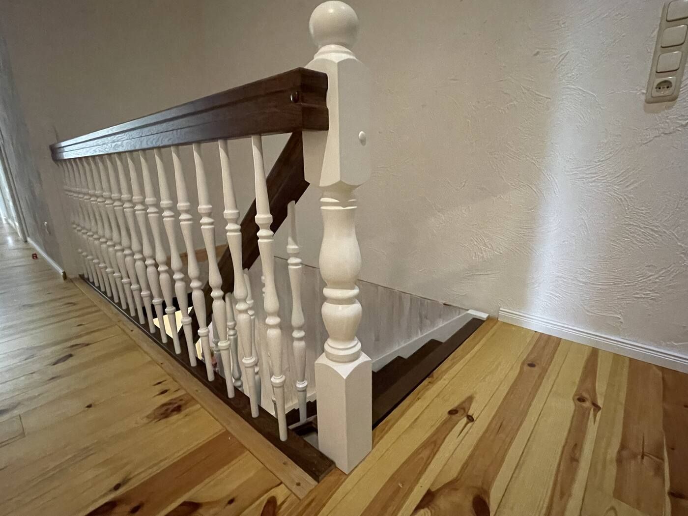 Eine Holztreppe mit weißem Geländer und Holzboden.