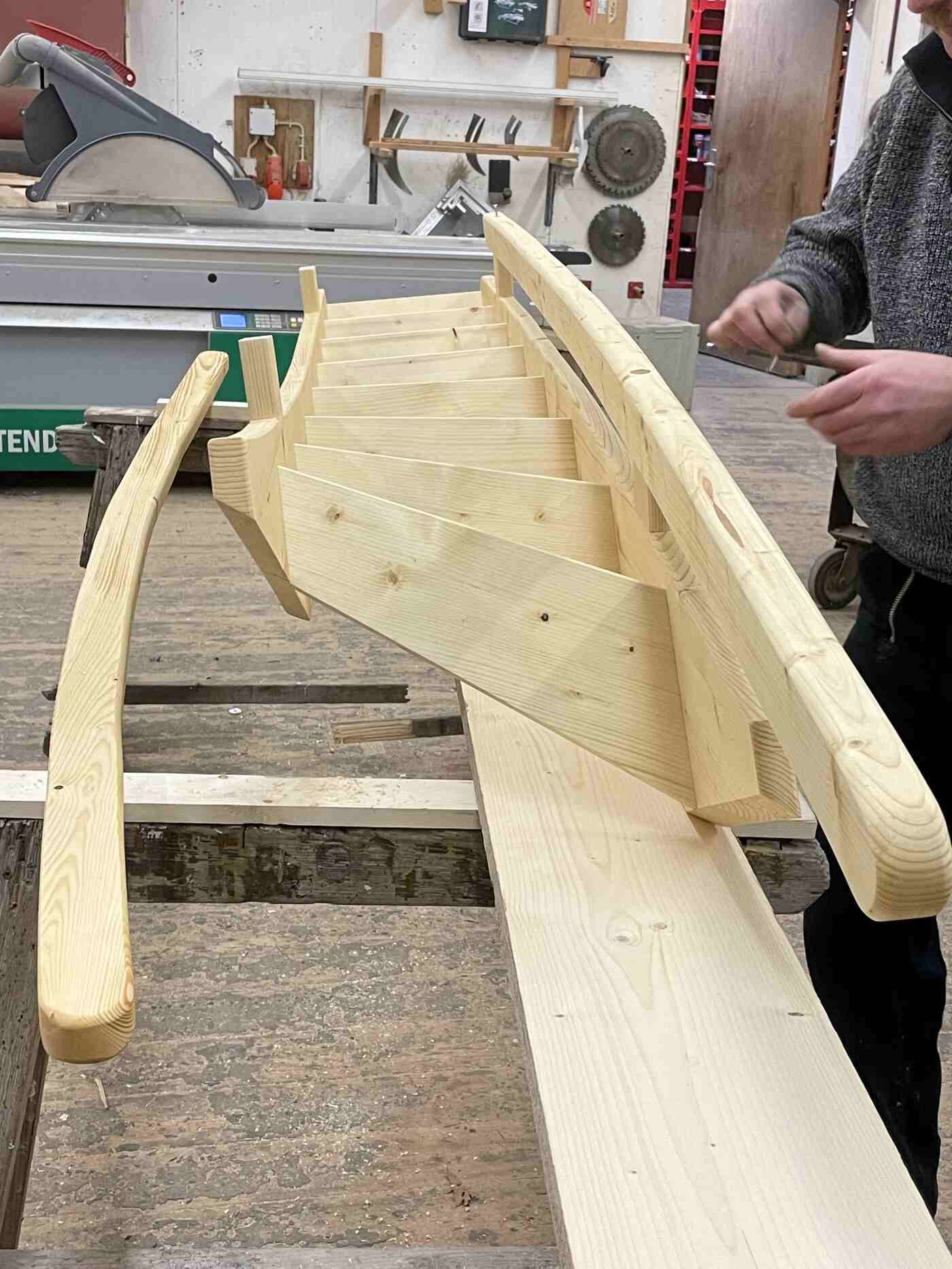 Ein Mann arbeitet in einer Werkstatt an einem Holzboot