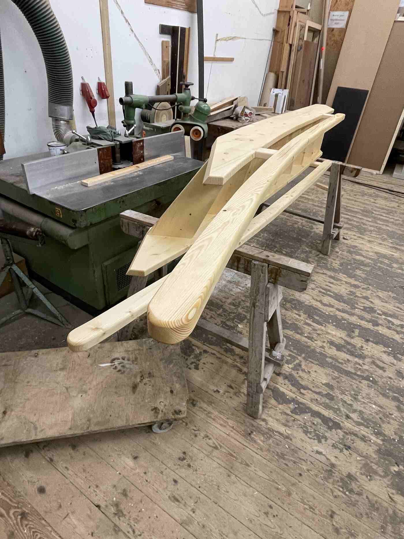 In einer Holzwerkstatt liegt ein Stück Holz auf einem Holztisch.