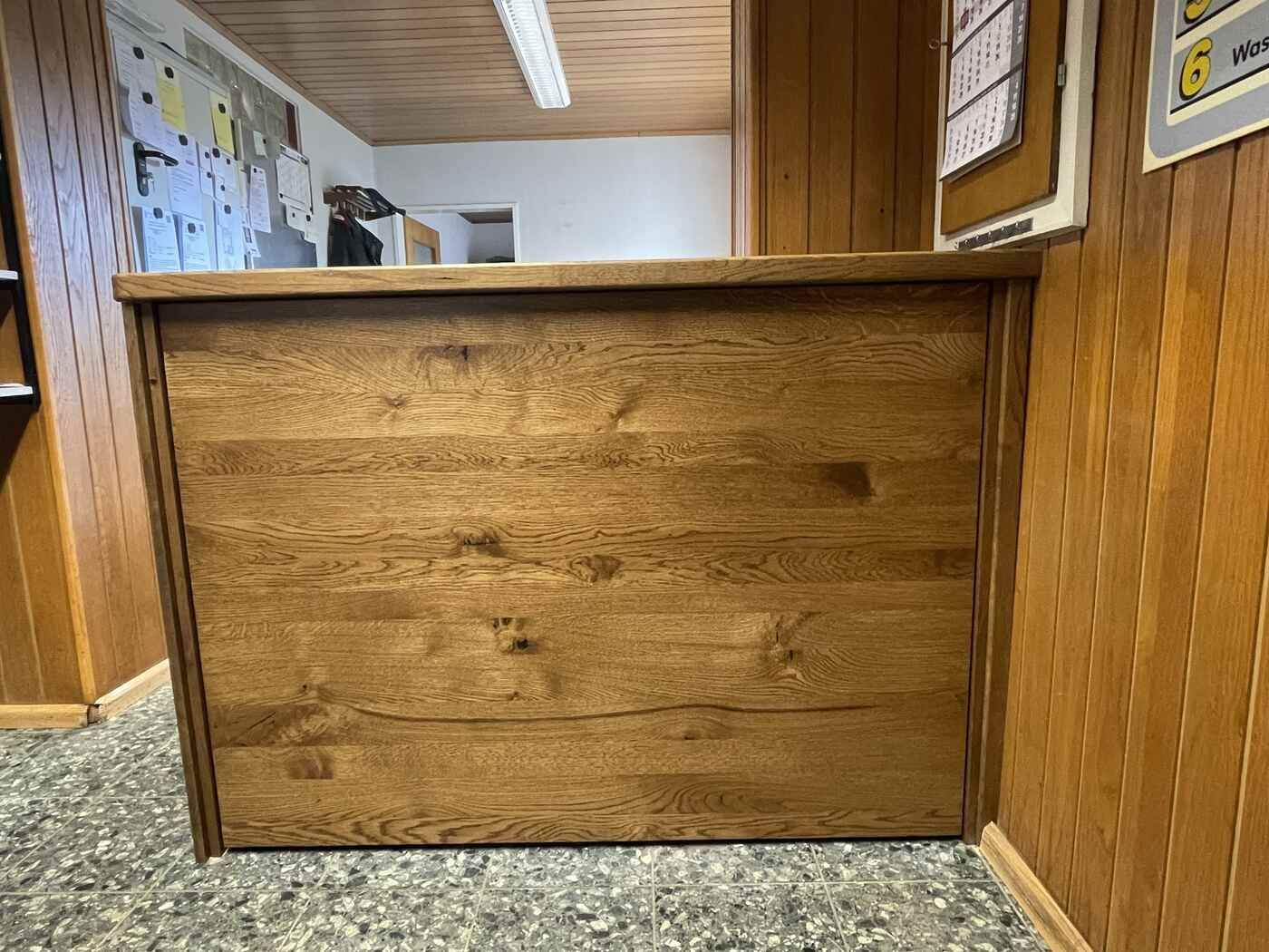 Eine Holztheke in einem Raum mit einem Kalender an der Wand.