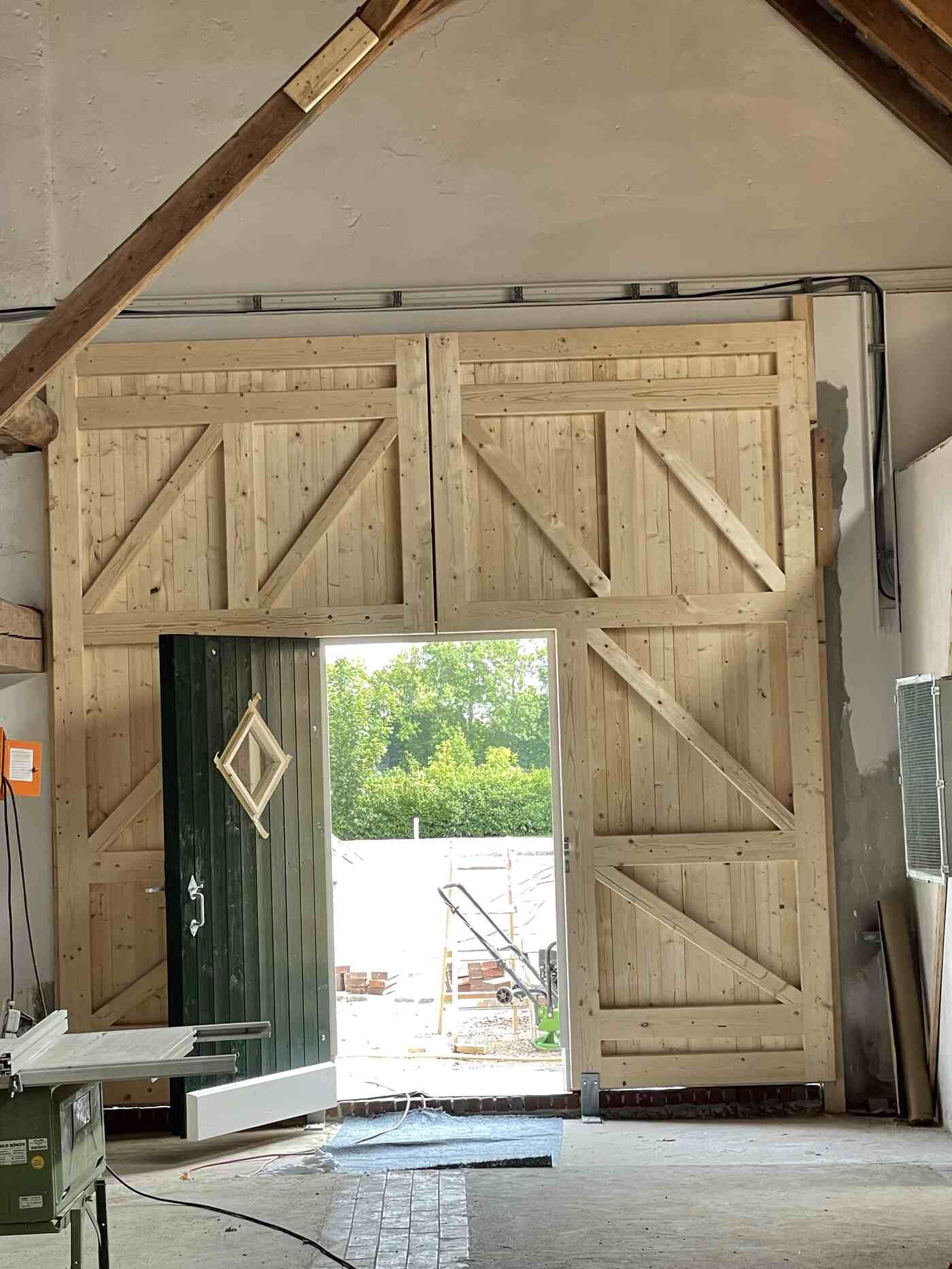 In einem Gebäude steht eine große Holztür offen