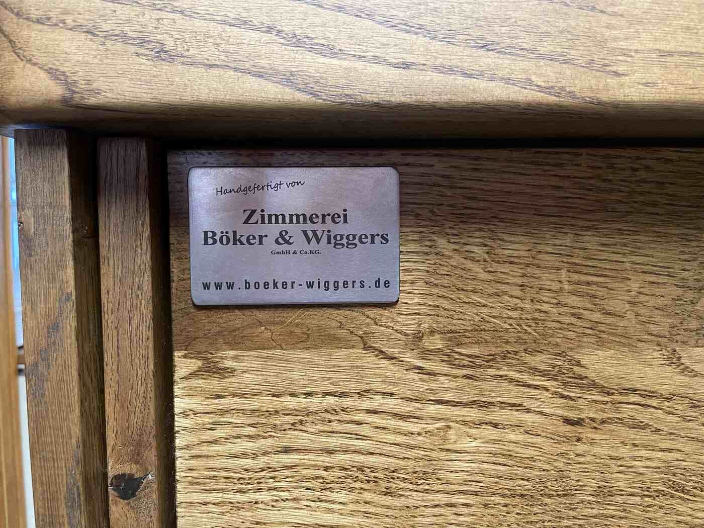 Ein Holzschrank mit einem Etikett darauf, auf dem steht: Zimmeret Bilker & Wiggers