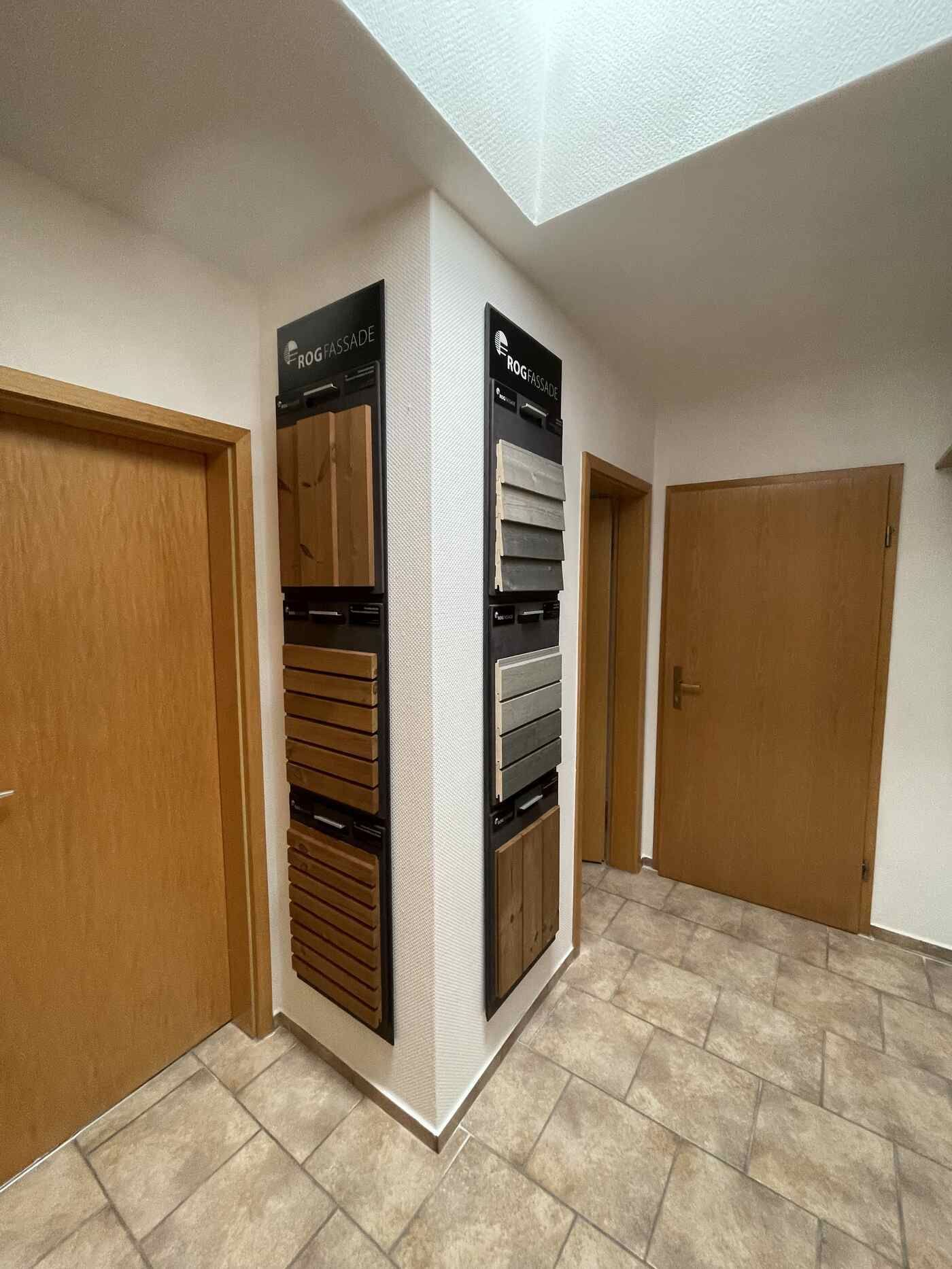 Ein Flur mit Holztüren und einer Ausstellung verschiedener Holzarten.