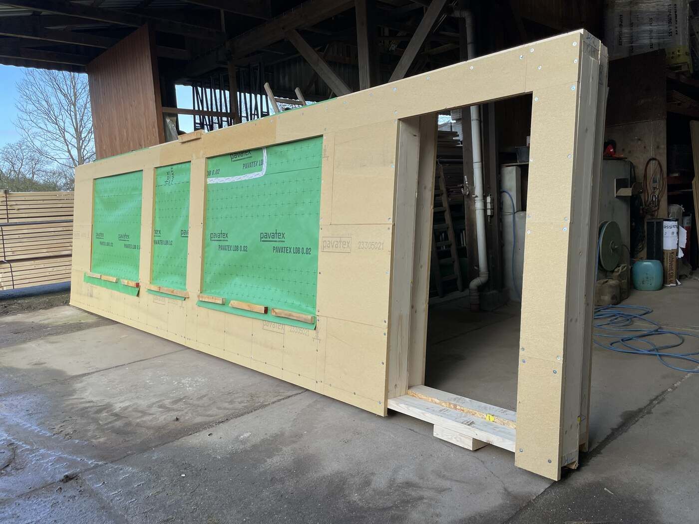 In einer Lagerhalle liegt ein großes Stück Holz auf dem Boden.