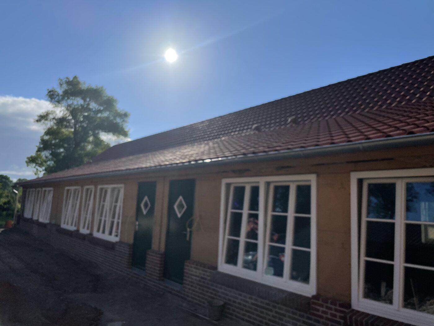 Ein Haus mit einem roten Ziegeldach und weißen Fenstern