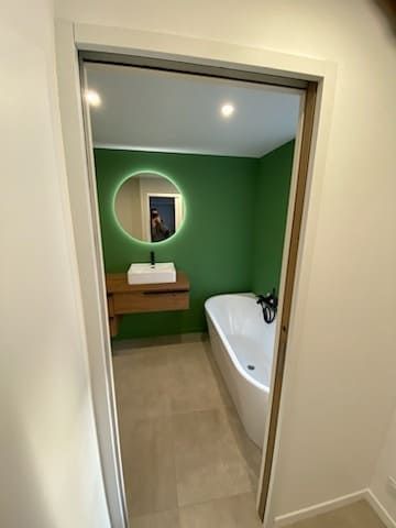 Salle de bains, vert et bois, grands carreaux, vue extérieure du couloir