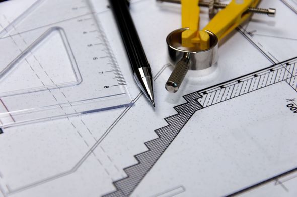 Zeichengeräte auf Architekturplänen: Bleistift, Zirkel und Lineal auf einem Schreibtisch