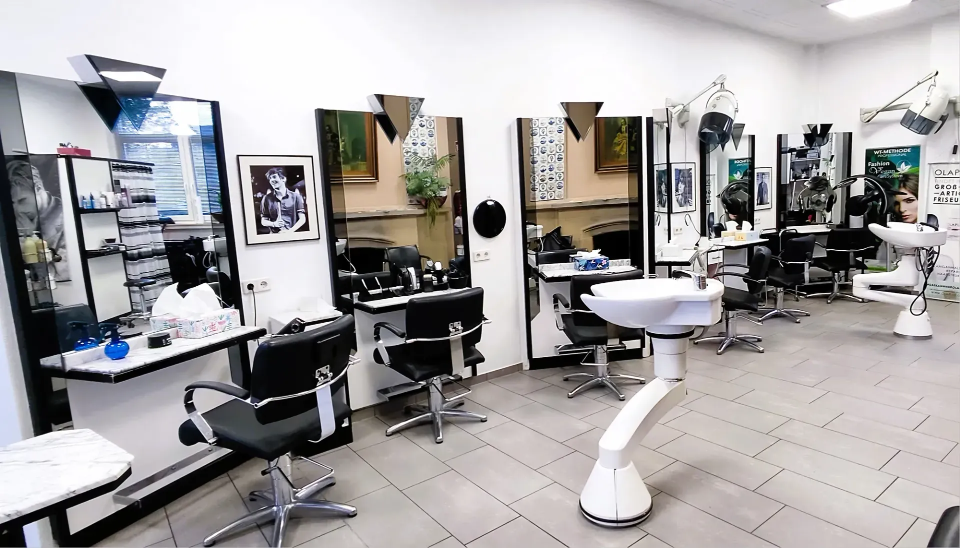 Ein Friseursalon mit vielen Stühlen und Spiegeln