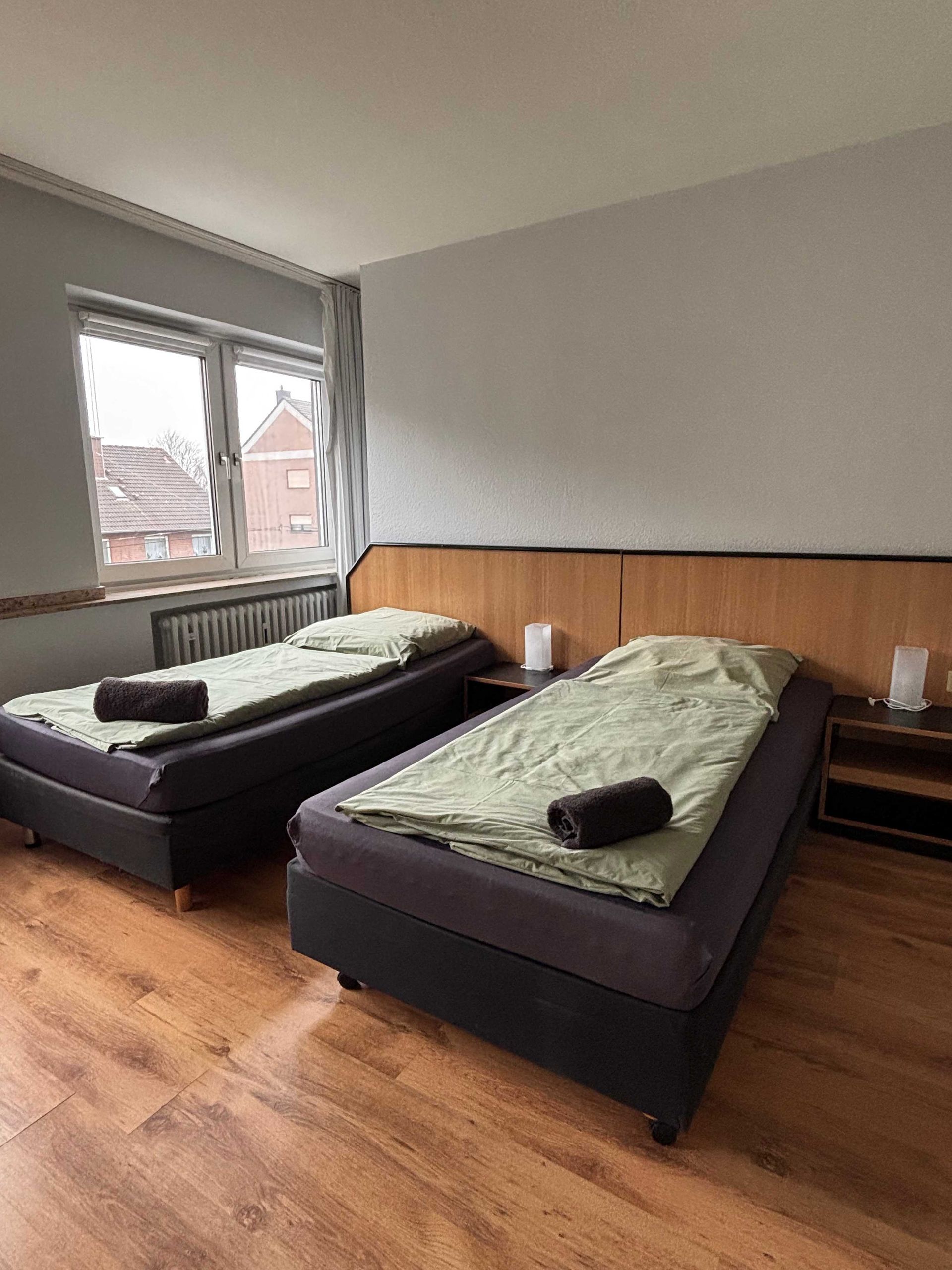 Ein Schlafzimmer mit zwei Betten und einem Fenster.