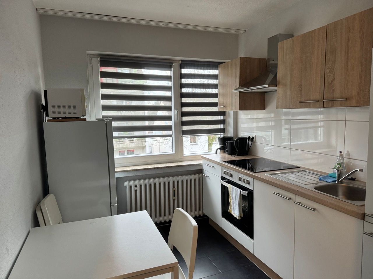 Eine Küche mit Tisch und Stühlen und einem Fenster