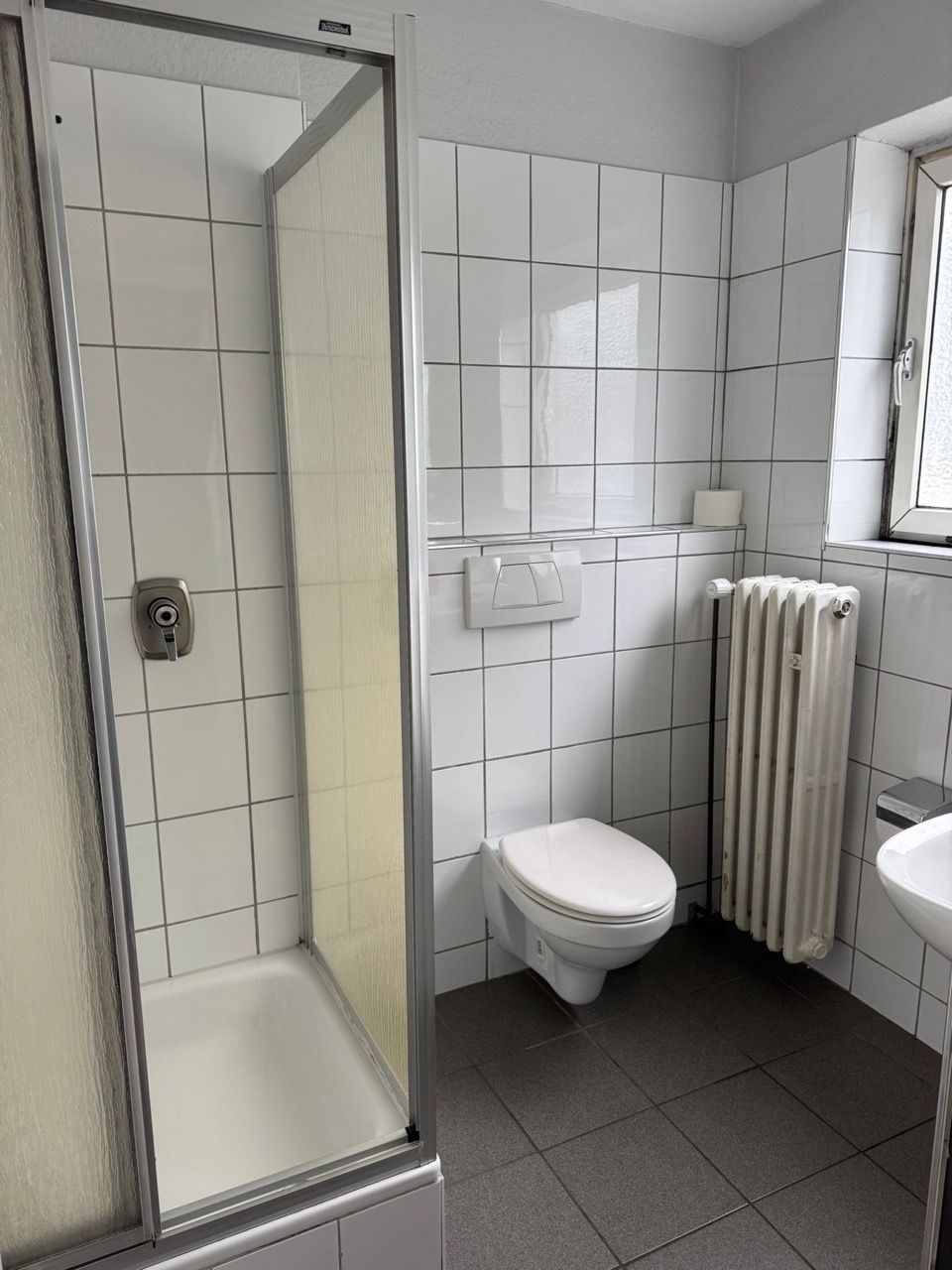 Ein Badezimmer mit Toilette, Waschbecken und Dusche