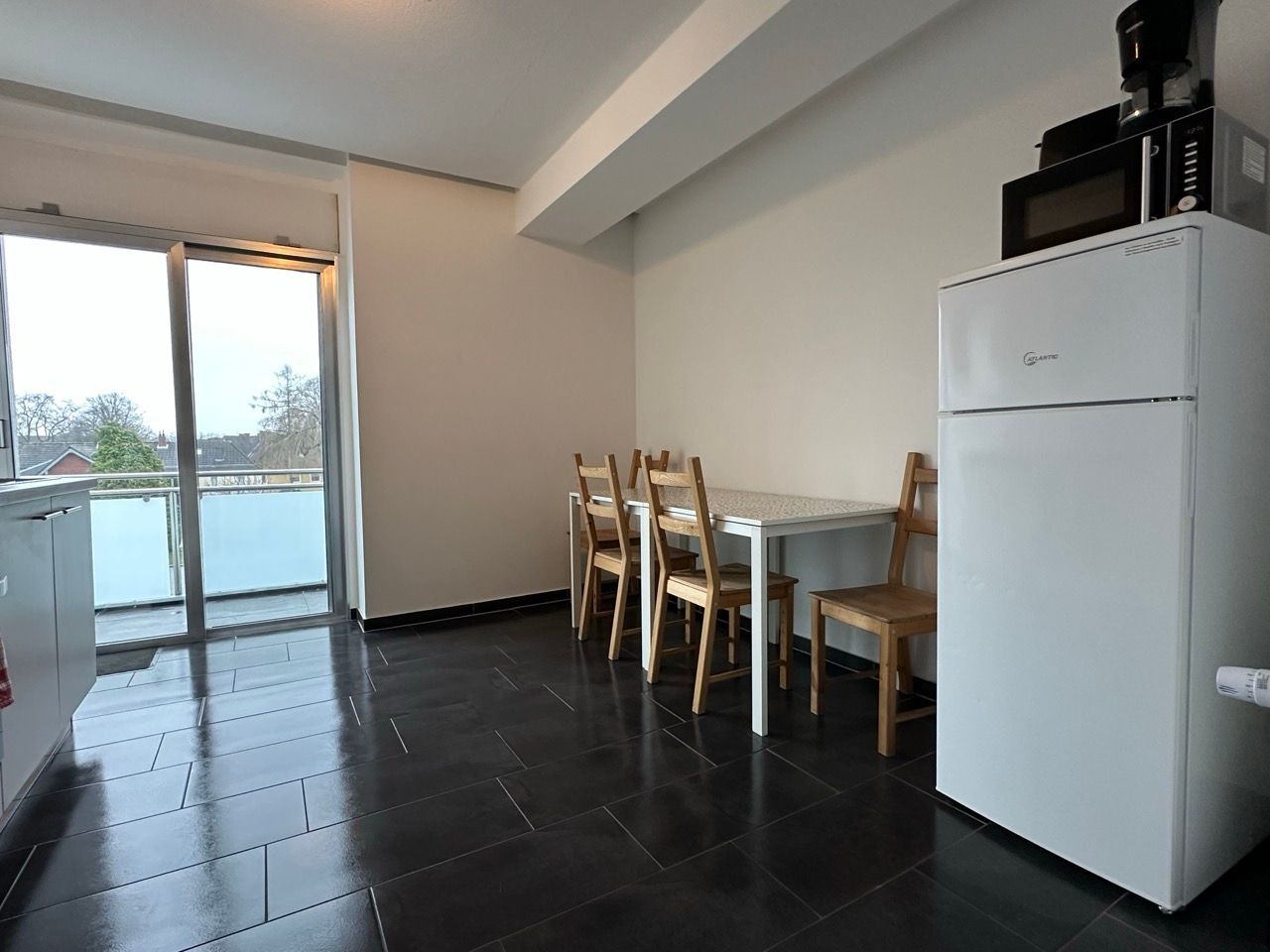 Eine Küche mit Tisch und Stühlen und einem Kühlschrank