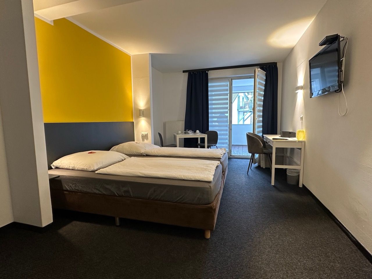 A hotel room with two beds , a desk and a television.