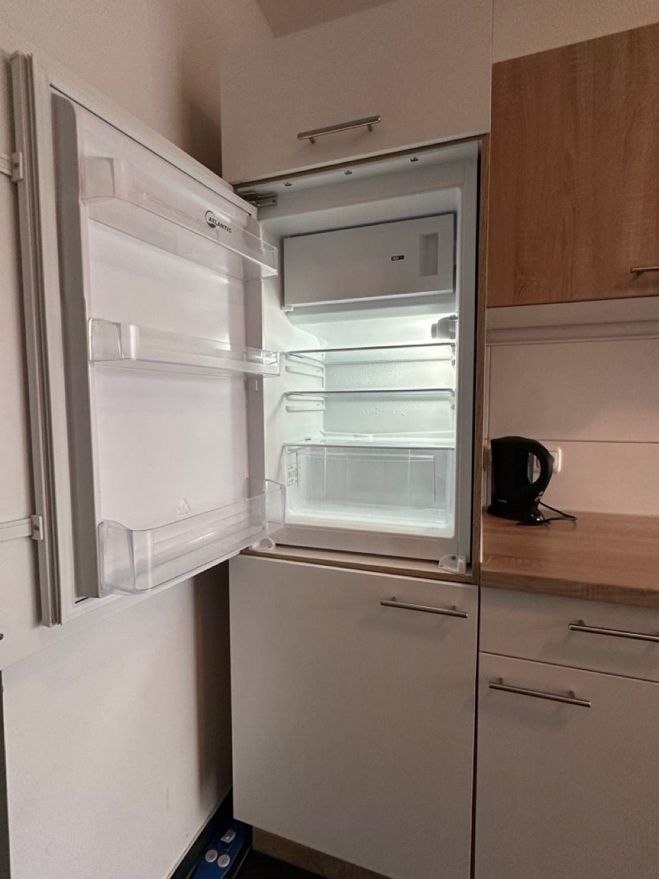 Ein Kühlschrank in einer Küche mit offener Tür.