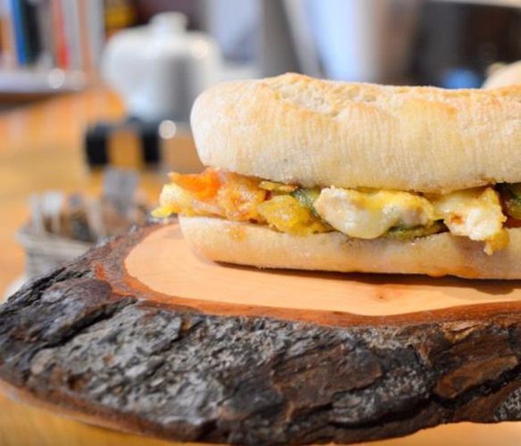 Un sándwich está sentado sobre un trozo de madera.