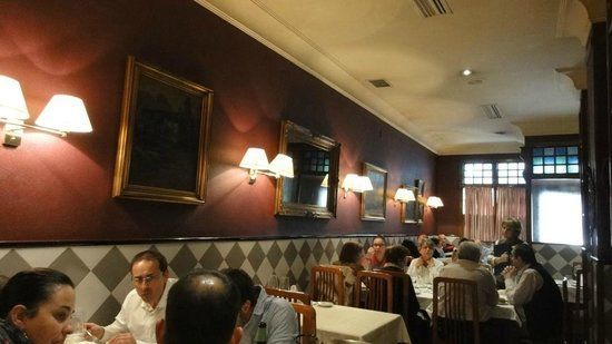 Un grupo de personas están sentadas en mesas en un restaurante.