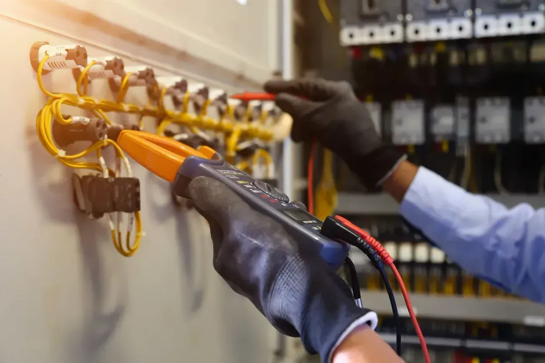 Un electricista está usando un multímetro para probar un circuito eléctrico.