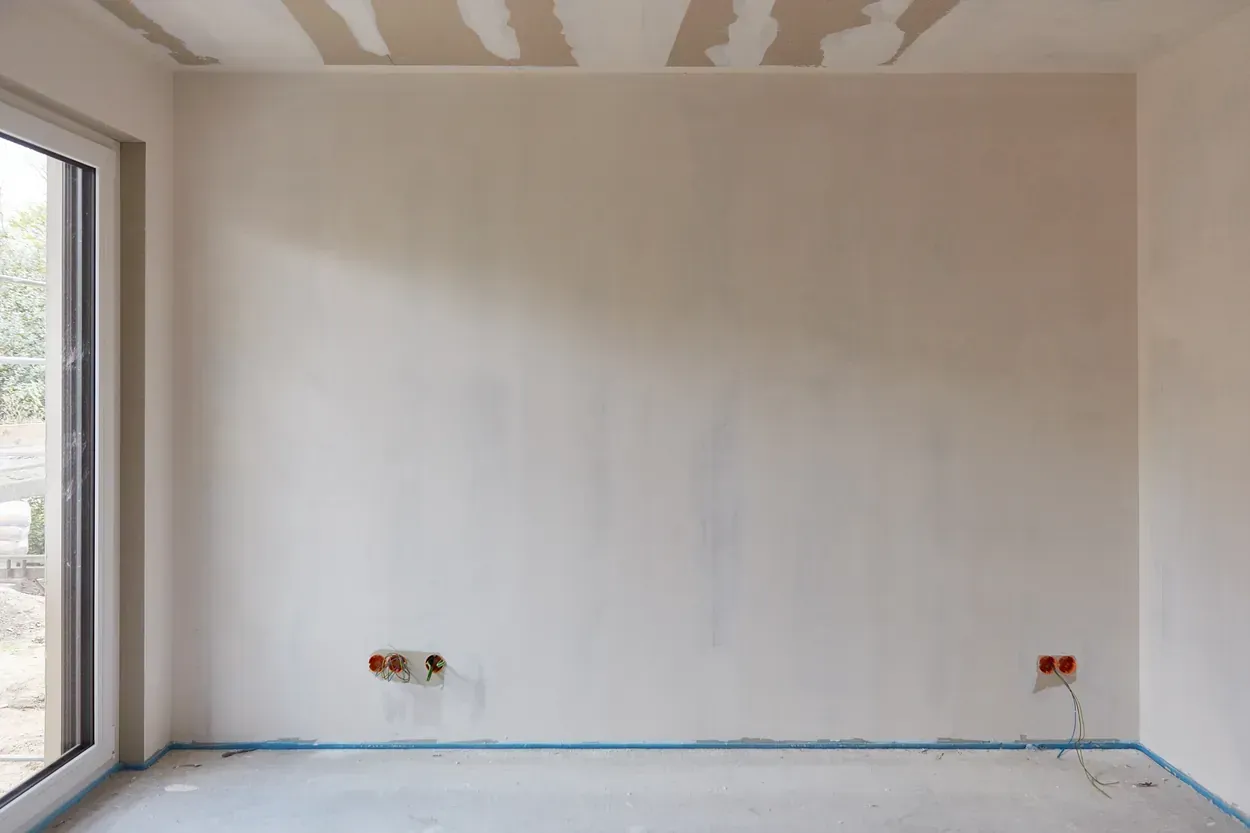 Una habitación vacía con una pared blanca y una ventana.