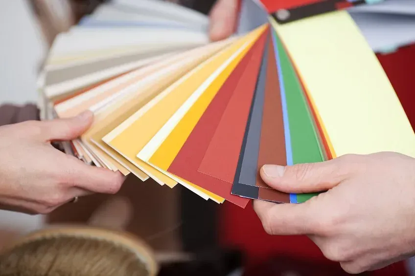 Una persona sostiene un abanico de colores en sus manos.