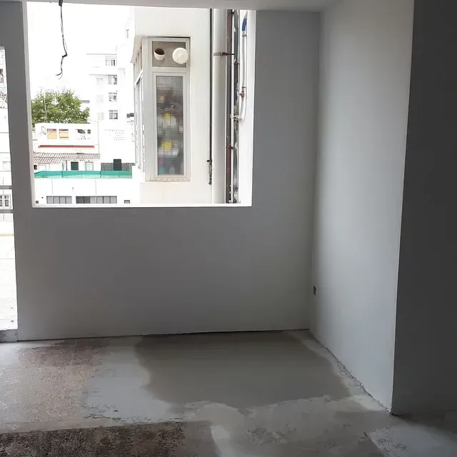 Una habitación vacía con una ventana y un balcón.
