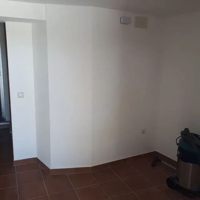 Hay una aspiradora en la esquina de la habitación.