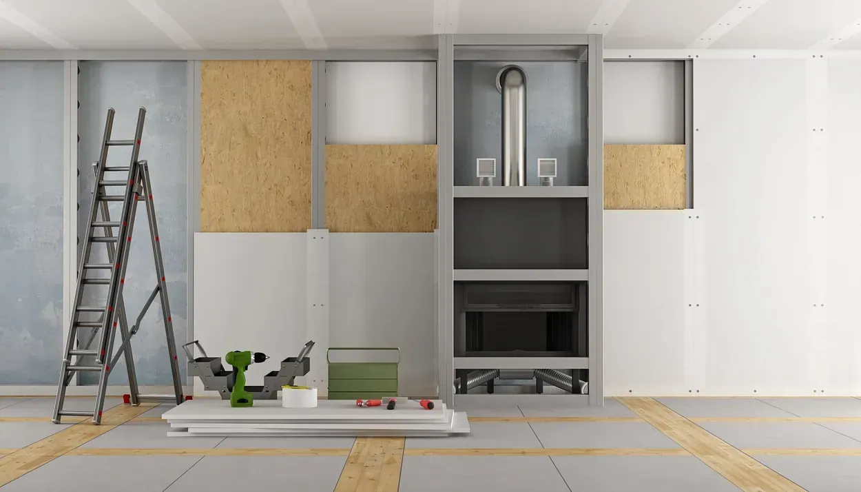 Se está remodelando una habitación con chimenea y escalera.