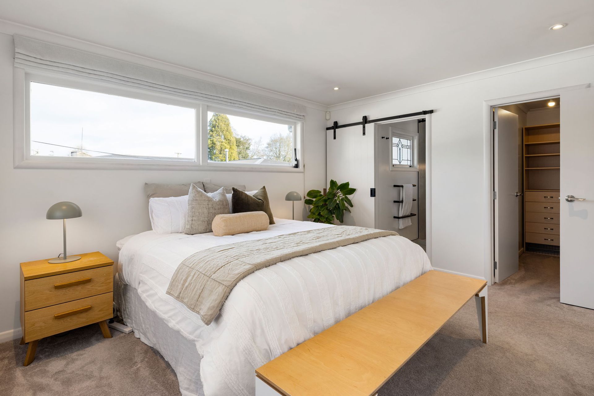 Bedroom with a bed, nightstand, sliding door to the bathroom, and a closet.