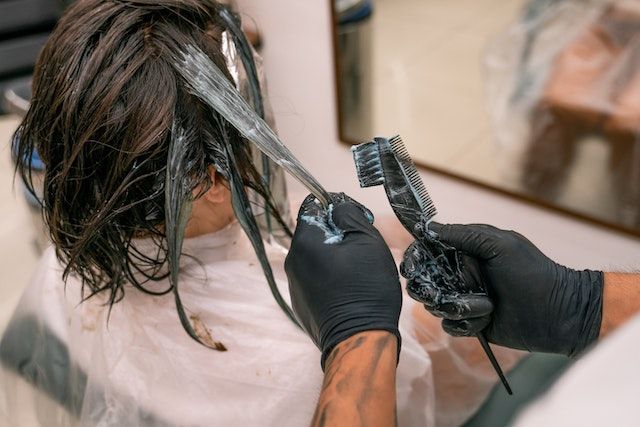 Una mujer se está cortando el pelo en una peluquería.