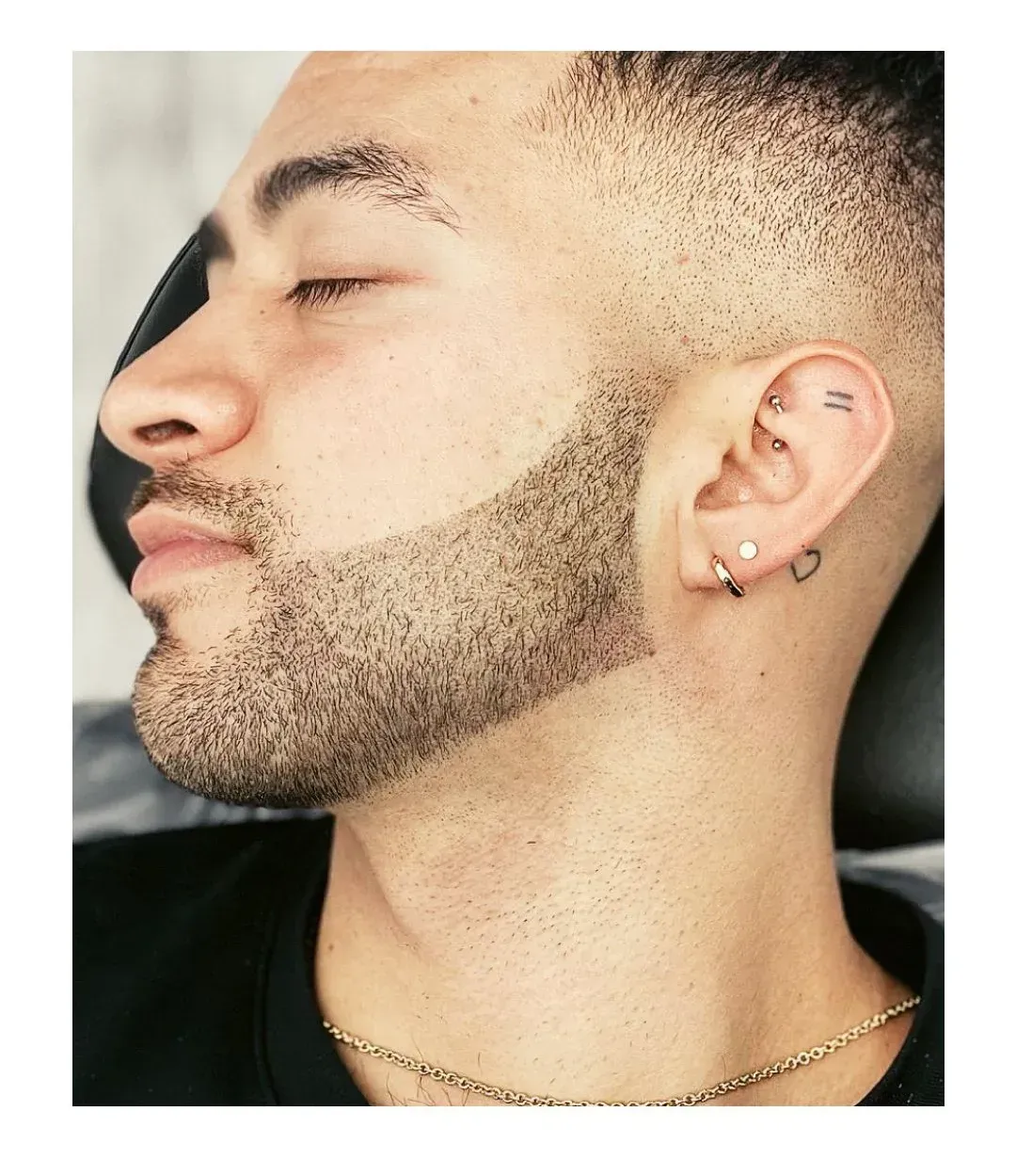 Hombre con barba rapada y corte de pelo degradado, 