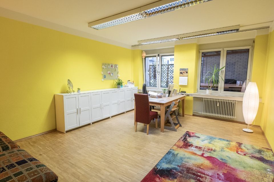 Sprechzimmer mit gelber Wand und buntem Teppich