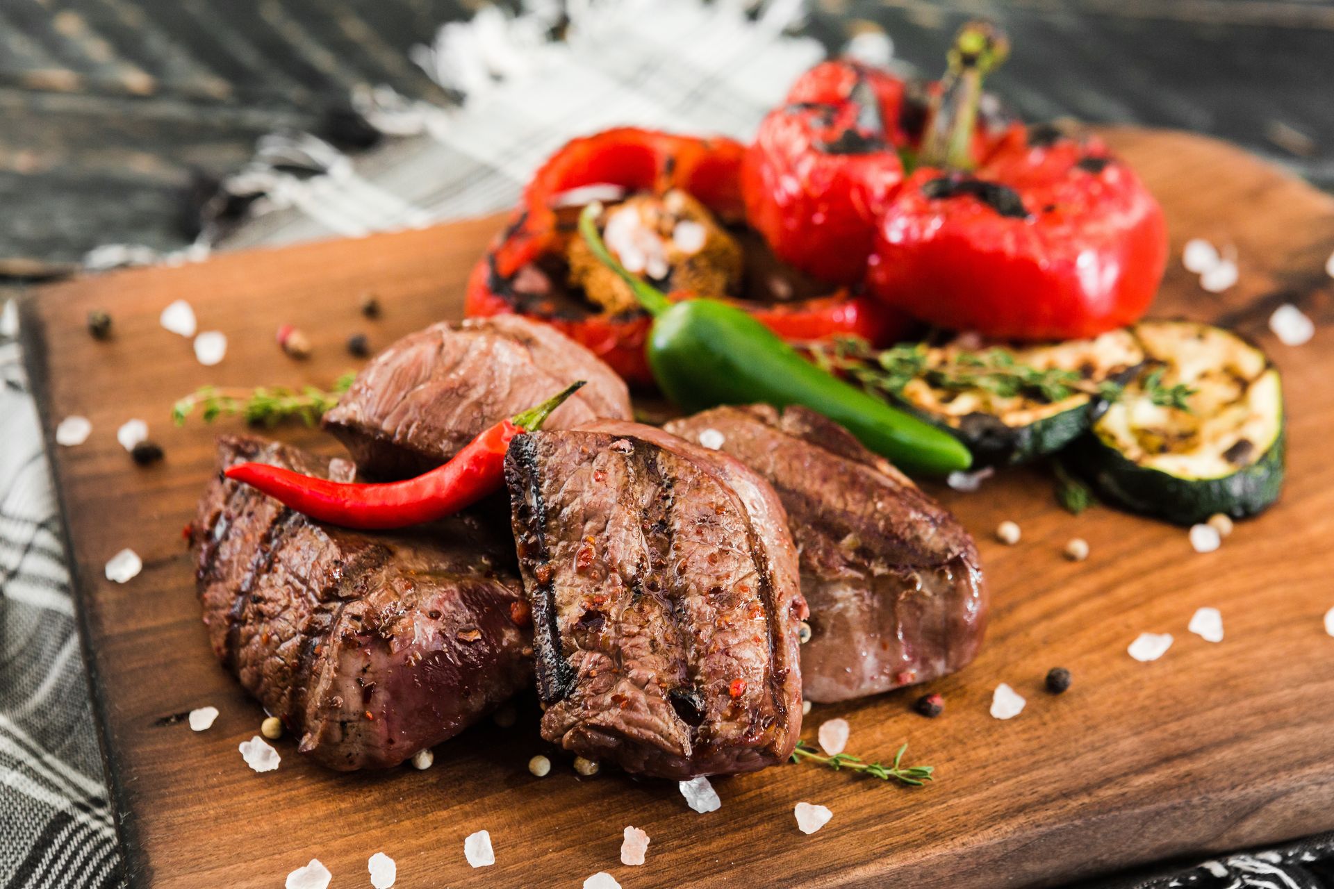 Steak with chili peppers on a wooden board