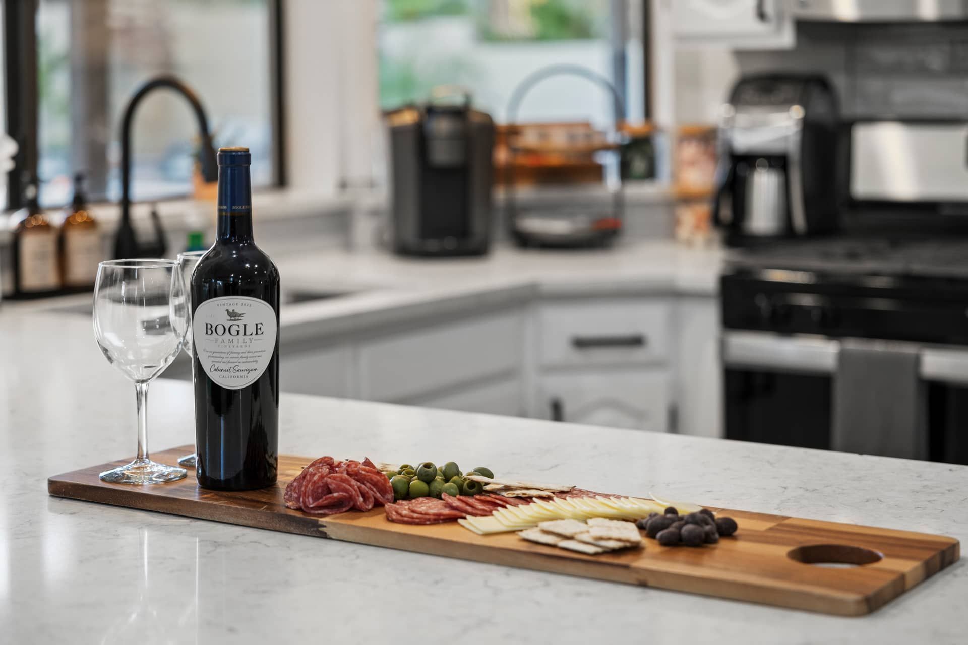Elegant charcuterie board and rosé wine setup in a luxury vacation rental kitchen, prepared by Bella Palazzo for arriving guests as part of five-star property management services.