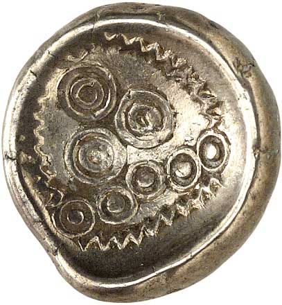 Eine Nahaufnahme einer Silbermünze mit Kreisen auf einem weißen Hintergrund.