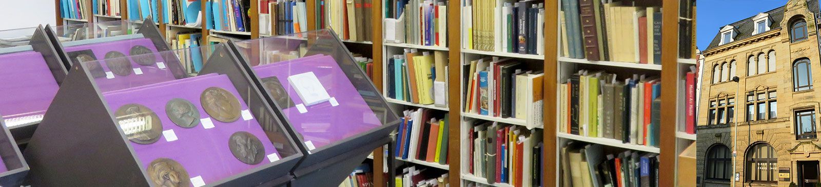 Eine Reihe Bücherregale in einer Bibliothek mit einem Gebäude im Hintergrund.