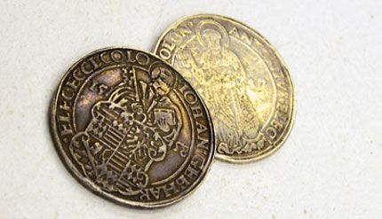 Zwei Münzen liegen übereinander auf einem Tisch