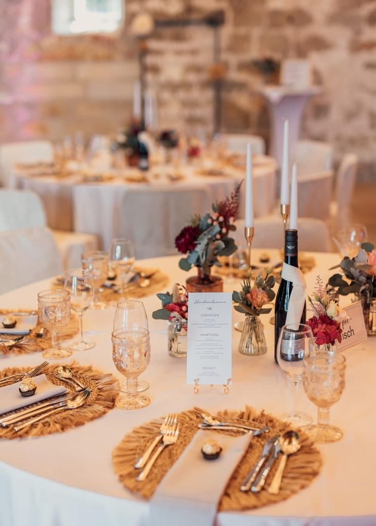 Tischdekoration für den Hochzeitsempfang mit floralen Mittelstücken und goldenen Akzenten.