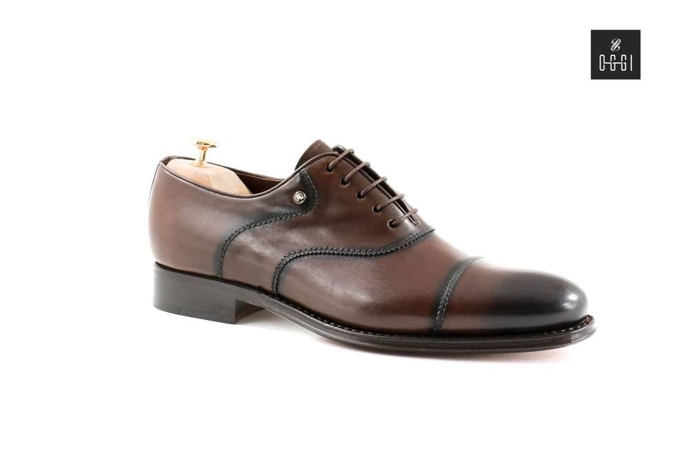 Une paire de chaussures marron et noires sur un embauchoir