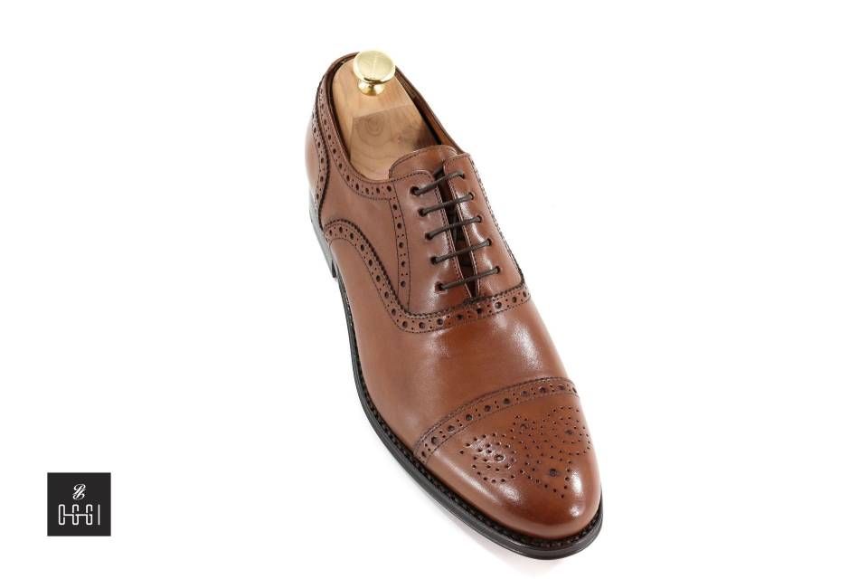 Une paire de chaussures marron avec un porte-chaussures en bois