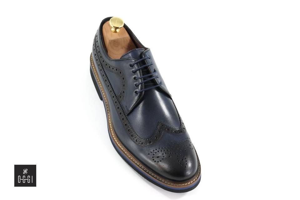 Une paire de chaussures brogue noires sur un support à chaussures en bois