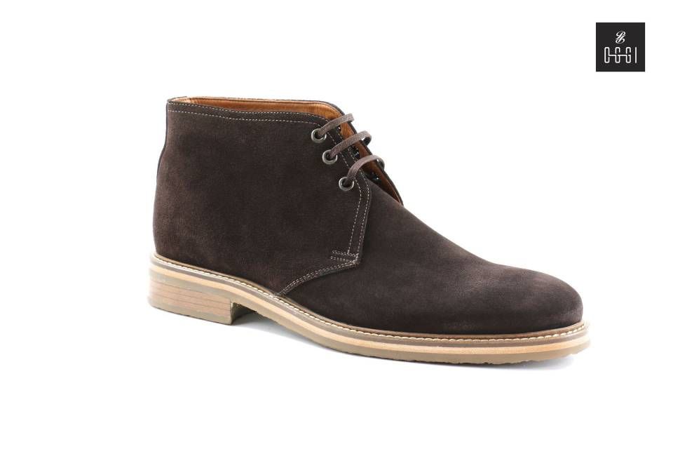 Une paire de bottines chukka en daim marron sur fond blanc