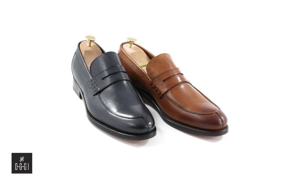 Une paire de mocassins noirs et marron sur fond blanc